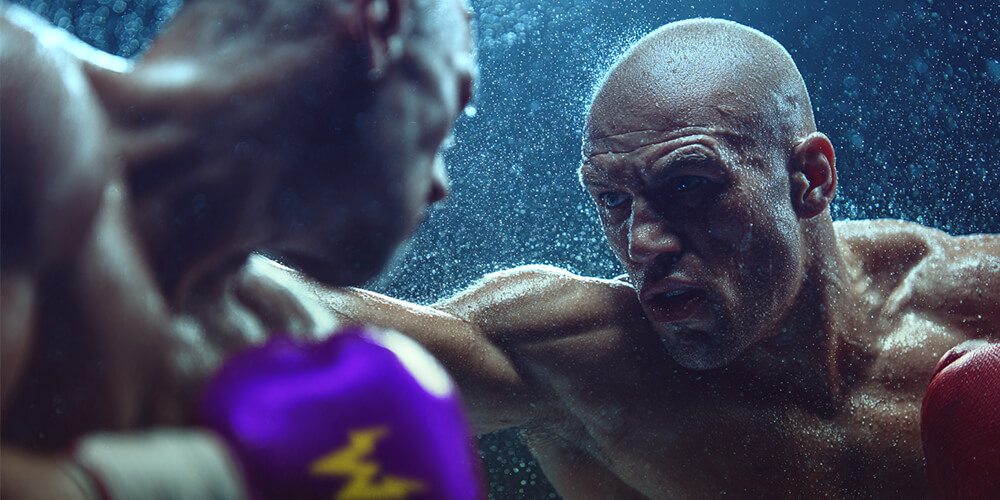 Lähikuva kahdesta miesnyrkkeilijästä ottelemassa.